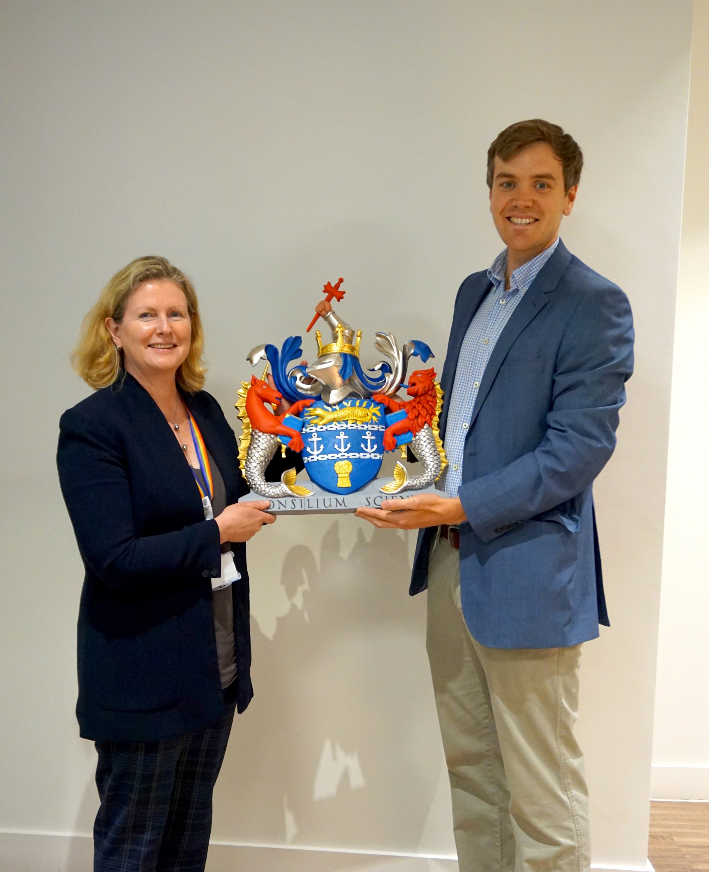 Sian Fisher CEO and William Barsley displaying the recently carved coats of arms